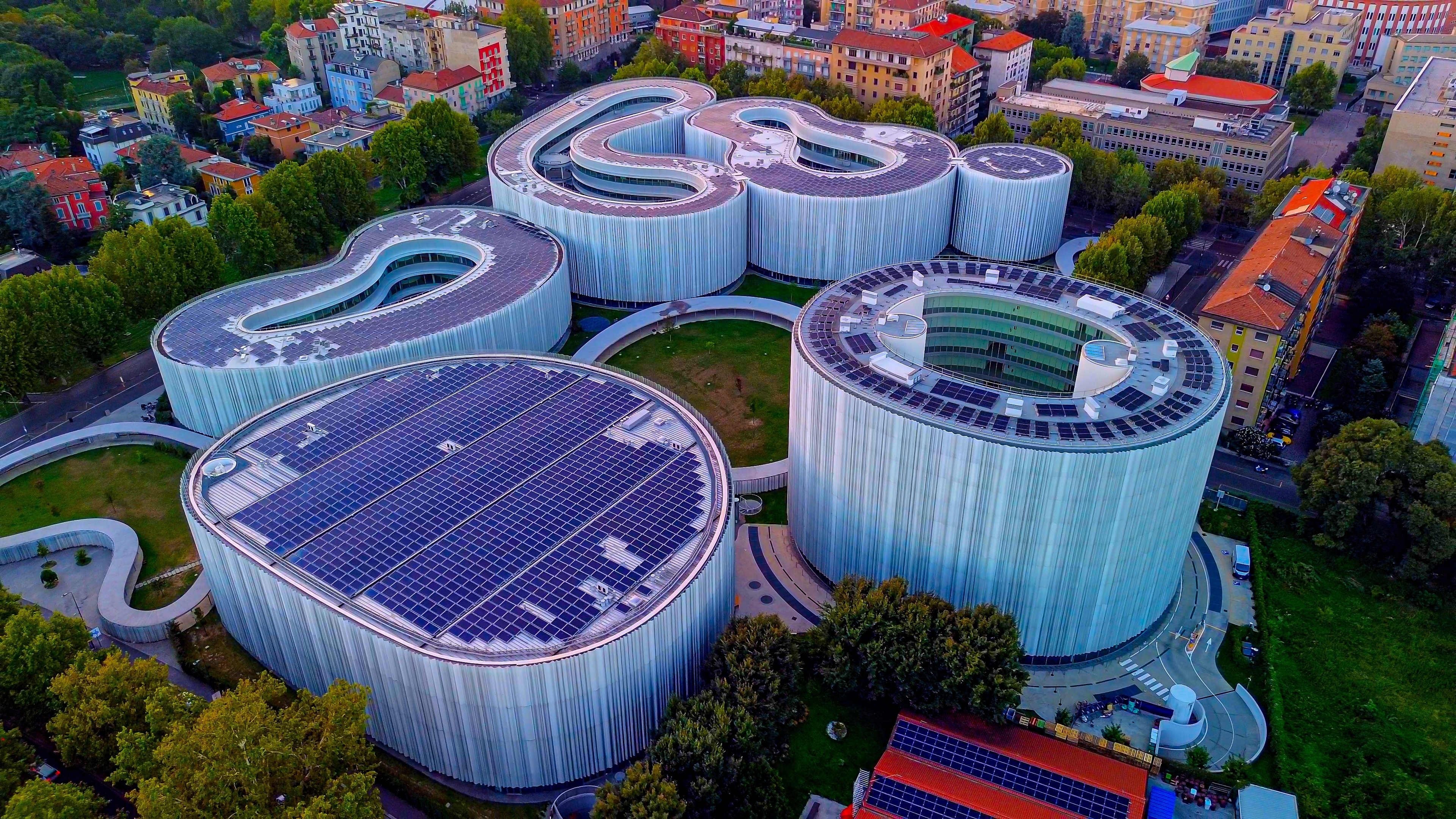Aerial view of curved buildings with solar panels covering their roofs