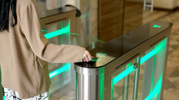Woman using an access card to open an office entrance gate