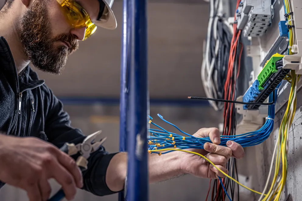 A male electrician working with wires