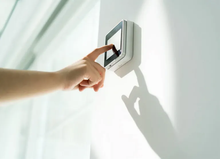 A hand interacting with a digital wall panel